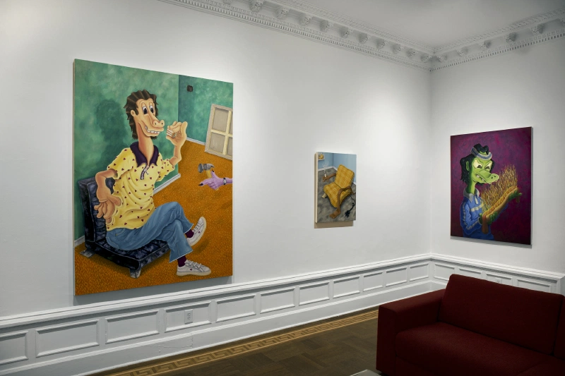 Three figurative paintings displayed around a fireplace in a gallery.