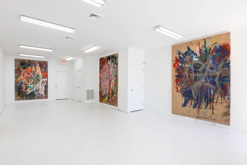 Large gestural abstract paintings displayed around a bright white gallery.